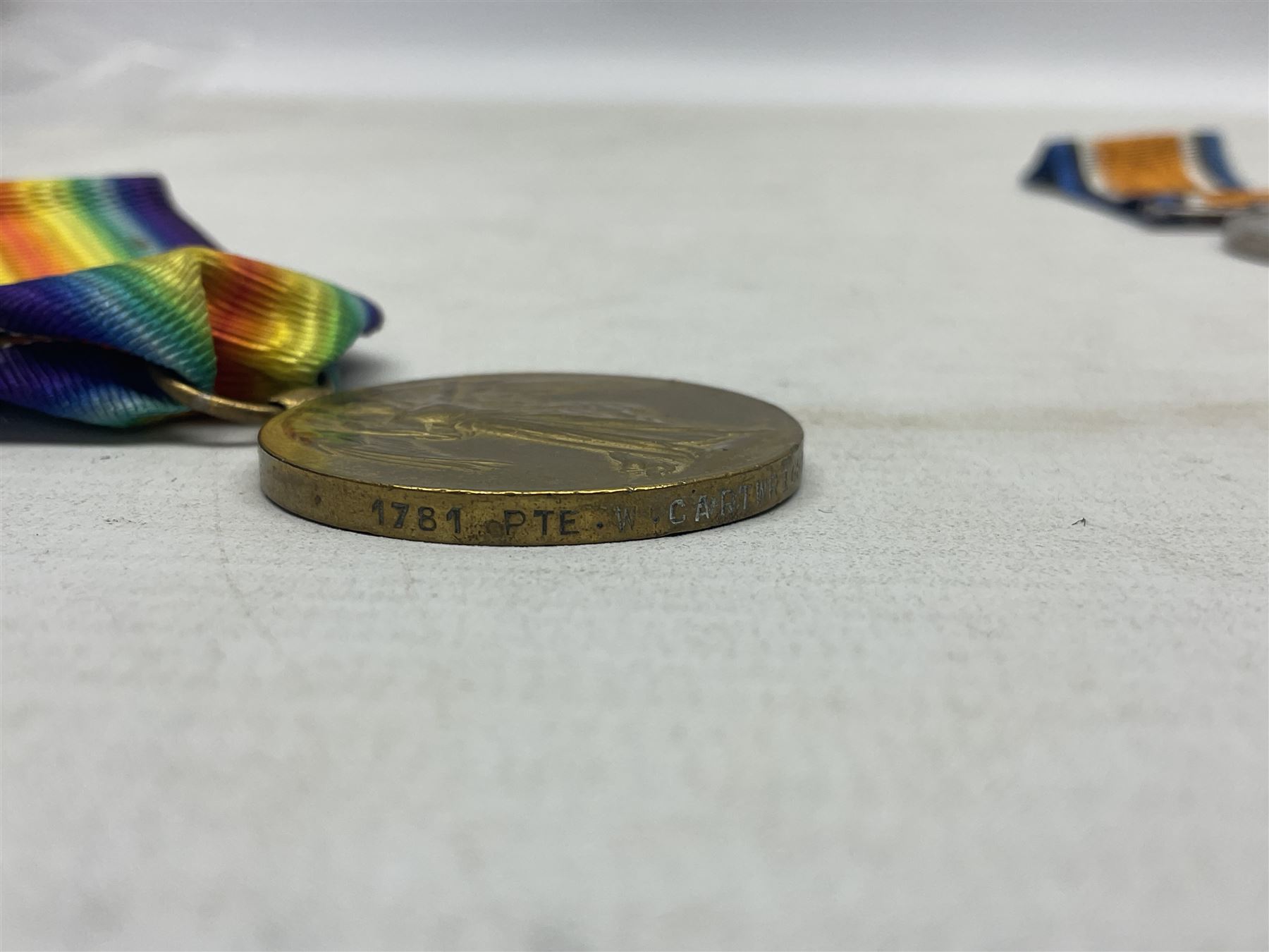WW1 group of three medals comprising British War Medal, 1914-15 Star and Victory Medal awarded to 1781 Pte. W. Cartwright Manch. R.; and another WW1 British War Medal awarded to 30284 Pte. W.H. Paterson Manch. R.; all with ribbons (4)