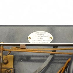 Lord Kelvins Patent electric current balance, no. 823, by Kelvin & James White Ltd Glasgow & London, with two pairs of horizontally mounted coils, suspended beam balance mounted on an ebonite base under glass and brass cover, with box of weights and accessories, raised on three wooden supports, W51cm H37.5cm