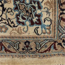 Persian Nain carpet, ivory field with concentric medallion in shades of blue and beige, surrounded by scrolling vines, palmettes and floral sprays, enclosed by multiple borders with intricate foliate motifs, originating from the Nain region of central Iran