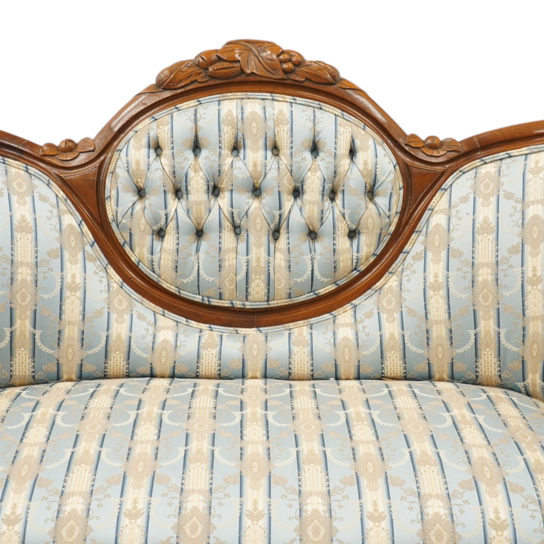 Victorian mahogany double cameo back sofa, the shaped back with central button upholstered oval panel and carved foliate crest above upholstered arms and seat, raised on cabriole legs terminating in castors