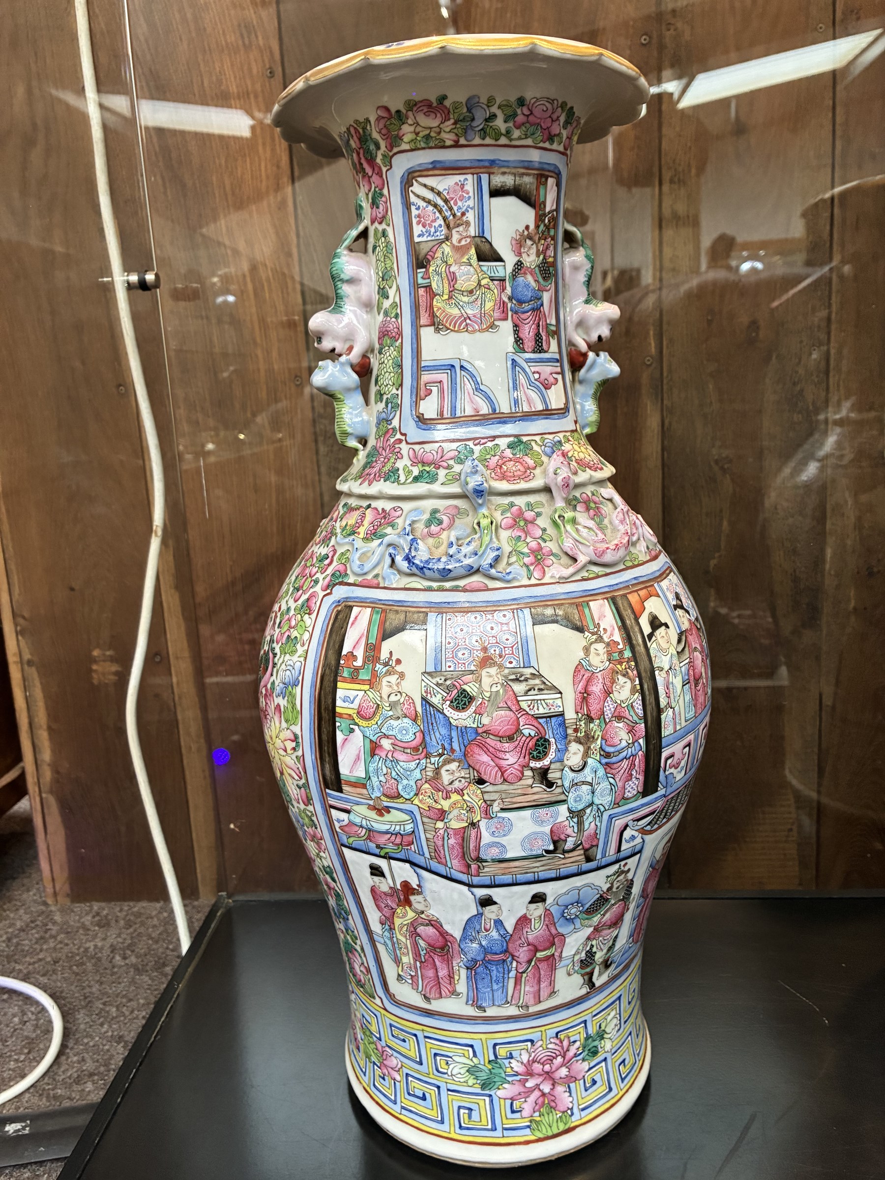 Large pair of 19th century Cantonese famille rose vases, each painted with various courtly scenes, including a display of warriors fighting on horseback before an official and his attendants, double Buddhist lion handles and applied at the shoulders with chilong, the lower band painted with Greek key motif, H58cm (2)