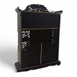 Early 20th century Japanese Meiji style carved hardwood cabinet, of symmetrical tiered form with pierced foliate fretwork panels and phoenix crest, fitted with sliding and hinged doors inset with hand-painted landscape panels depicting Mount Fuji, waterfalls, and lakeside dwellings, raised on shaped bracket supports