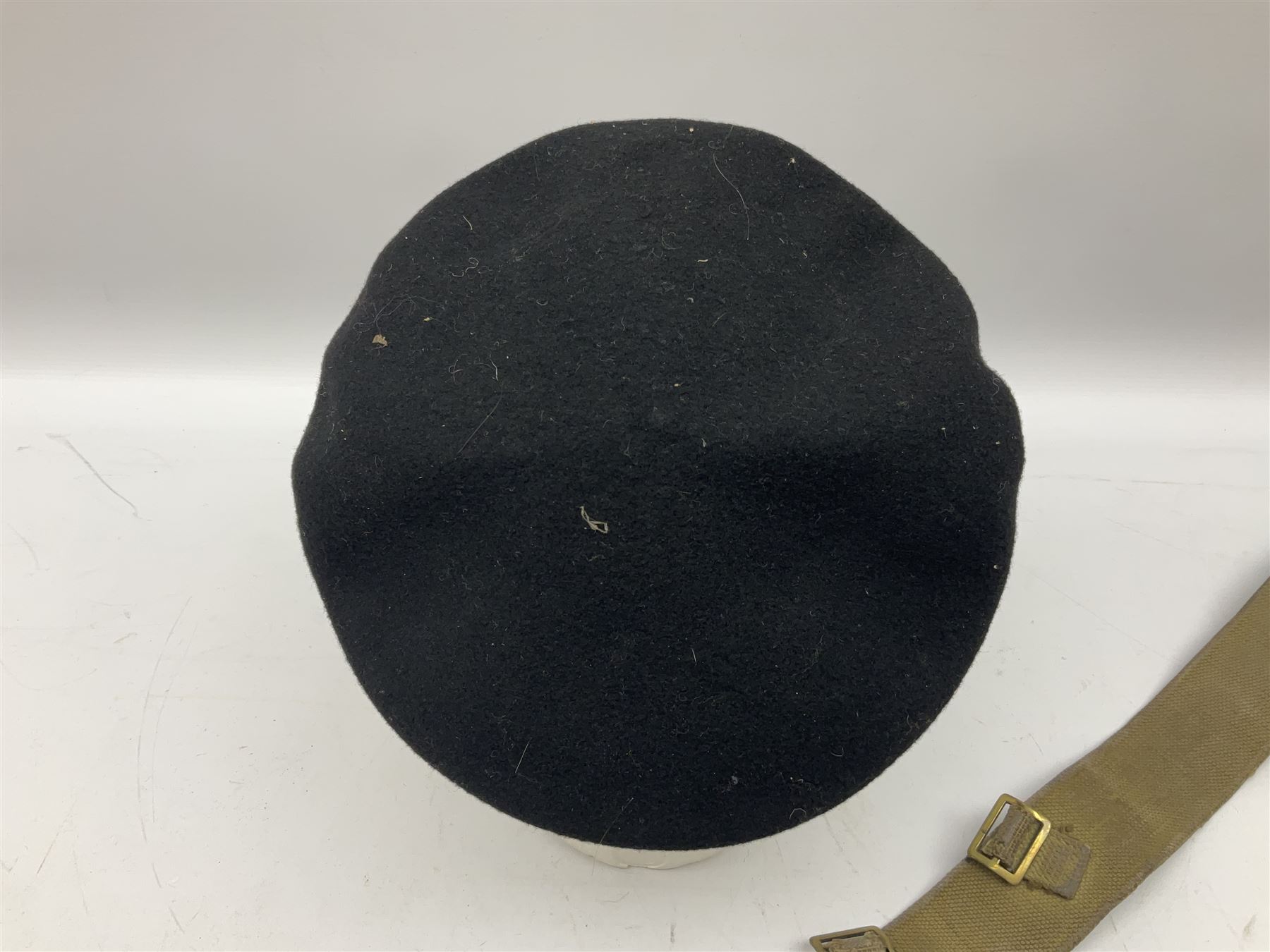 WW2 British black felt beret with Pioneer Corps cap badge, with Kangol Wear maker's mark dated 1943; and a British Army green webbing belt (2)