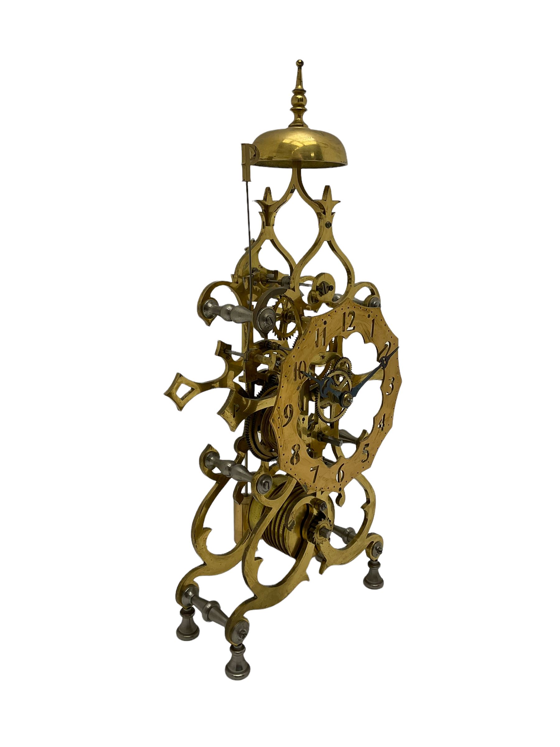 20th century scroll pattern Skeleton clock to the construction design of John Wilding, with an 8-day fusee movement and passing strike, with lantern pinions and brass wheels, Skeletonised brass dial with pierced Arabic numerals, cylindrical pendulum bob, with bespoke key and original construction book. 
John Wilding was a highly respected engineer and clockmaker publishing many books on the construction and repair of Fusee and weight driven clocks.

