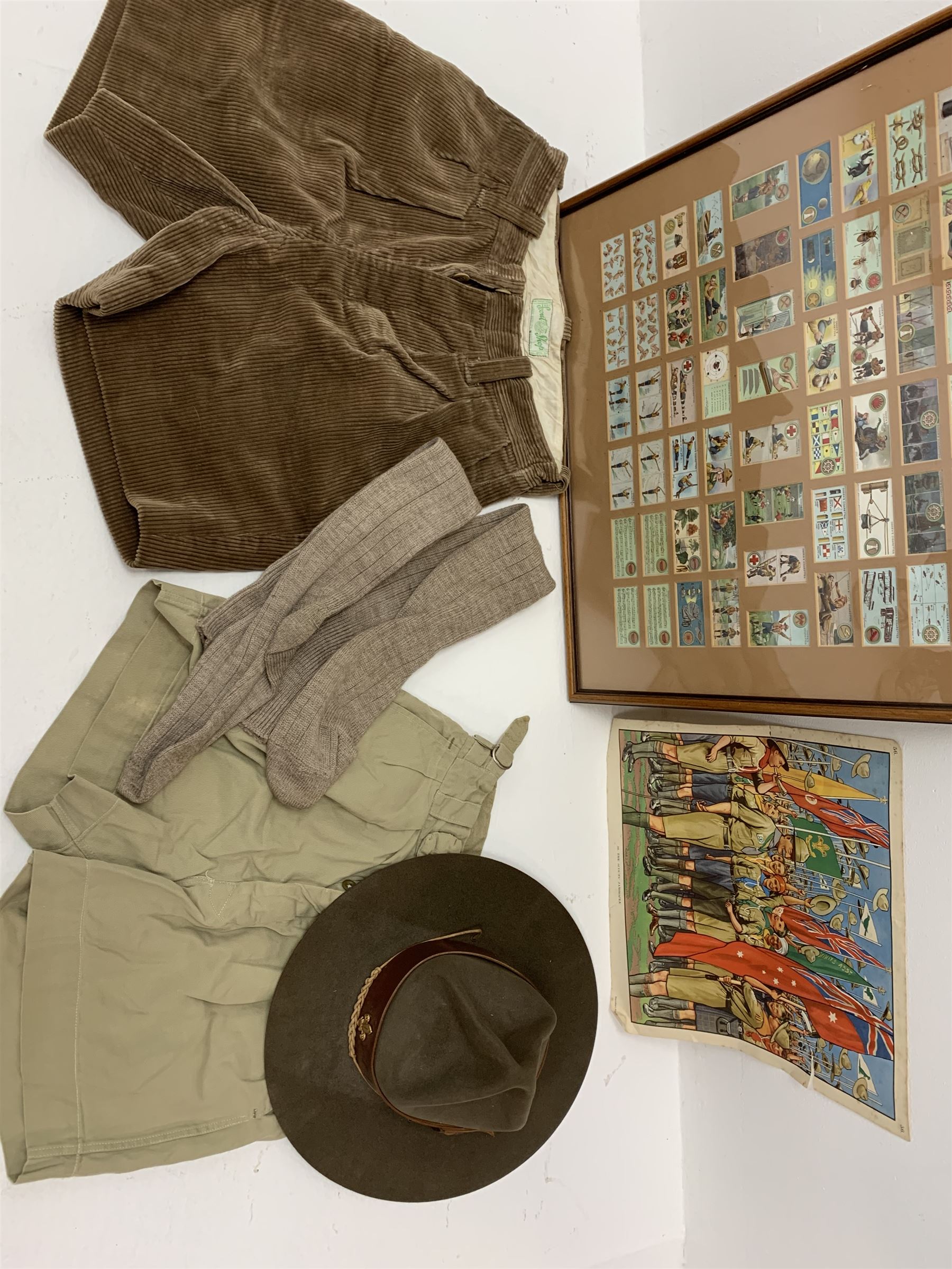 Mid 20th century Boy Scouts uniform, comprising corduroy shorts, further pair of shorts, two shirts, socks, and felt hat, together a framed collection of Ogden's 'Boy Scots' cigarette cards, and an unframed print of Lord Baden Powell. 