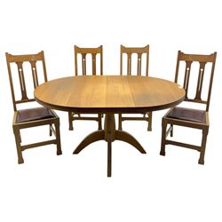 Contemporary light oak round extending dining table with four chairs, table has fold out leaf attached underneath on four out-swept legs, Oak chairs with straight top rail over twin slat back with pierced motifs, brown leather seat with brass studs, square legs joined by plain stretcher 