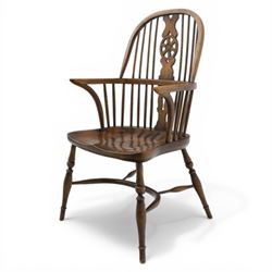 Late 19th century stained elm and beech Windsor armchair, the arched hoop back with pierced wheel splat above shaped lower splat between turned spindles, shaped arm rail on turned supports, saddle seat, raised on turned legs united by a crinoline stretcher