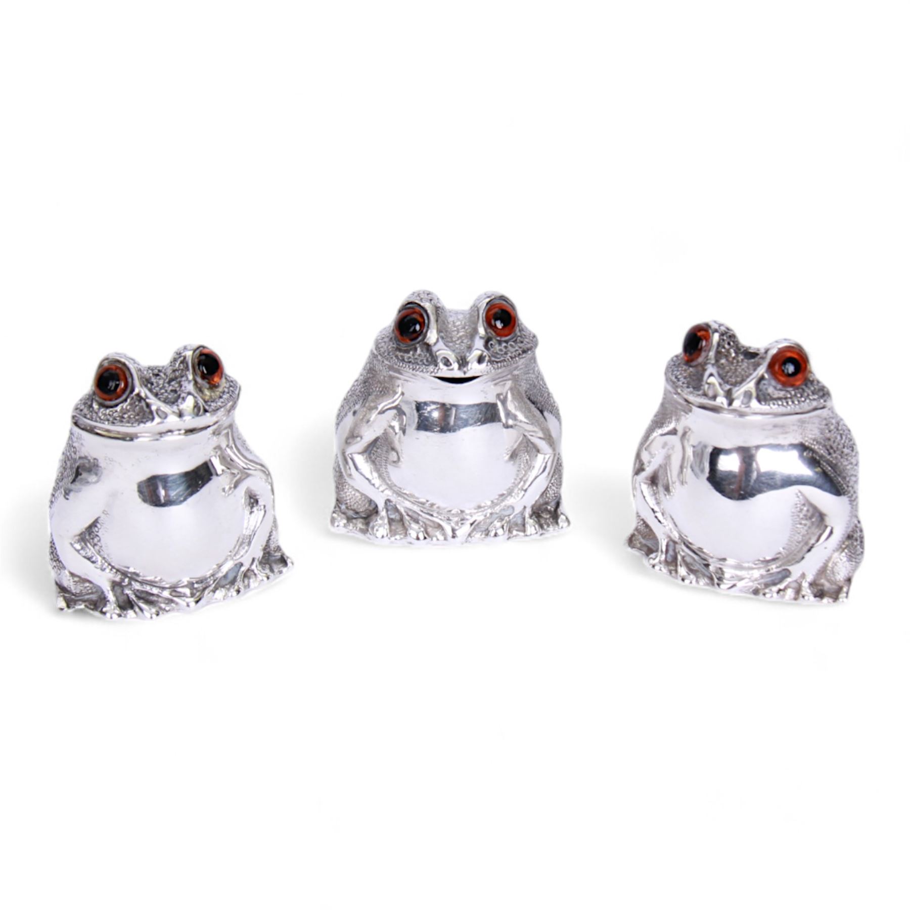 Modern silver three piece novelty cruet set, comprising salt, pepper and mustard, modelled as seated toads with textured backs and inset glass eyes,  hallmarked William Comyns & Sons Ltd, London 1967, H5cm