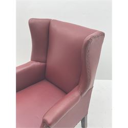  20th century wing back armchair, upholstered in studded red leather, raised on cabriole supports          