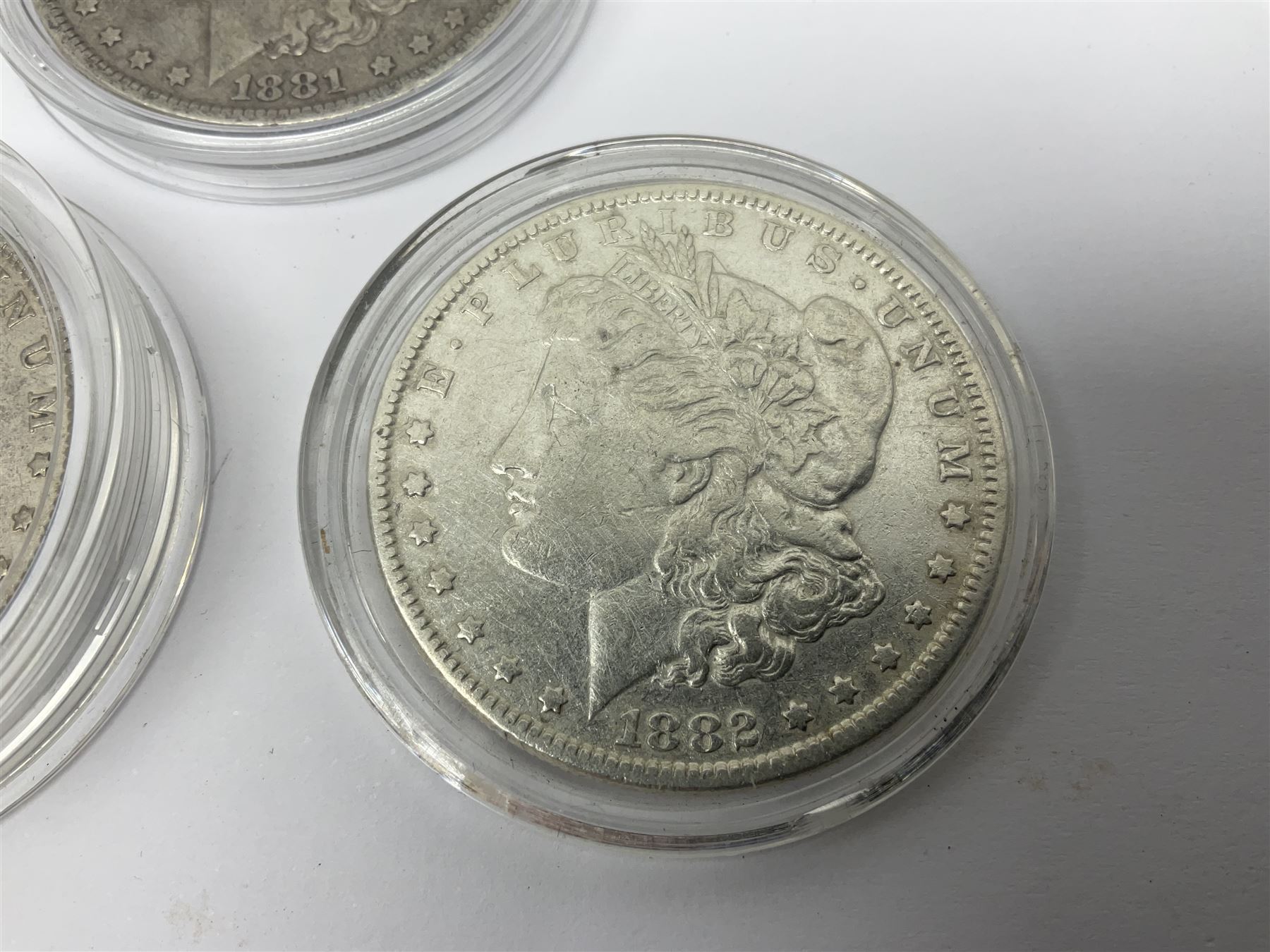 Three United States of America silver Morgan dollar coins dated 1881 O, 1882 and 1882 O