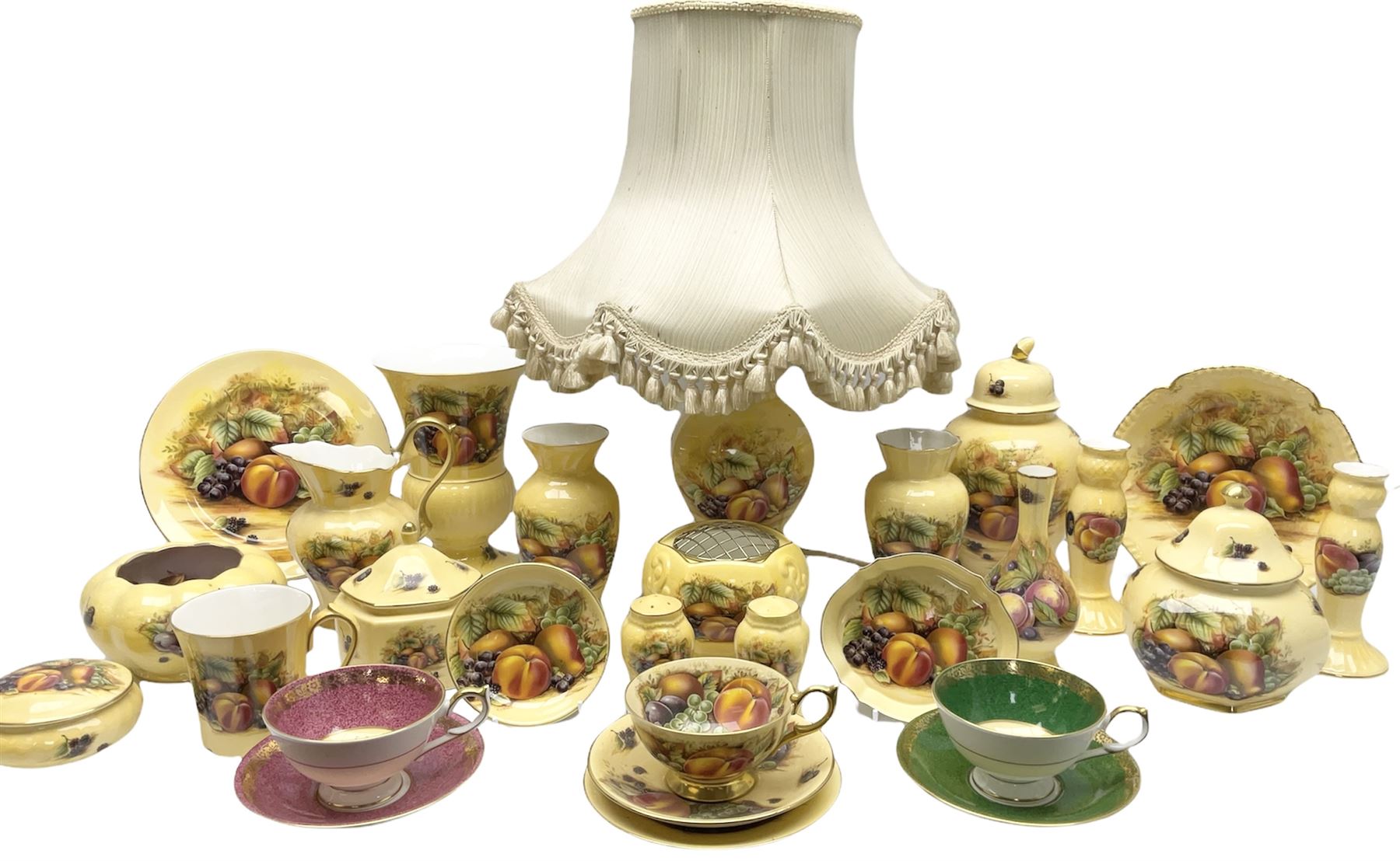 Collection of Aynsley Orchard Gold pattern wares, comprising lamp base, three jars and covers, six vases or various size and form, large jug, lidded dish, pair of cruets, pair of candlesticks, mug, two pin dishes, lobed dish, tea cup, saucer, size plate, and cake plate, and two further cups and saucers, each cup decorated with central Orchard Gold reserve to the interior against a mottled pink or green ground. 