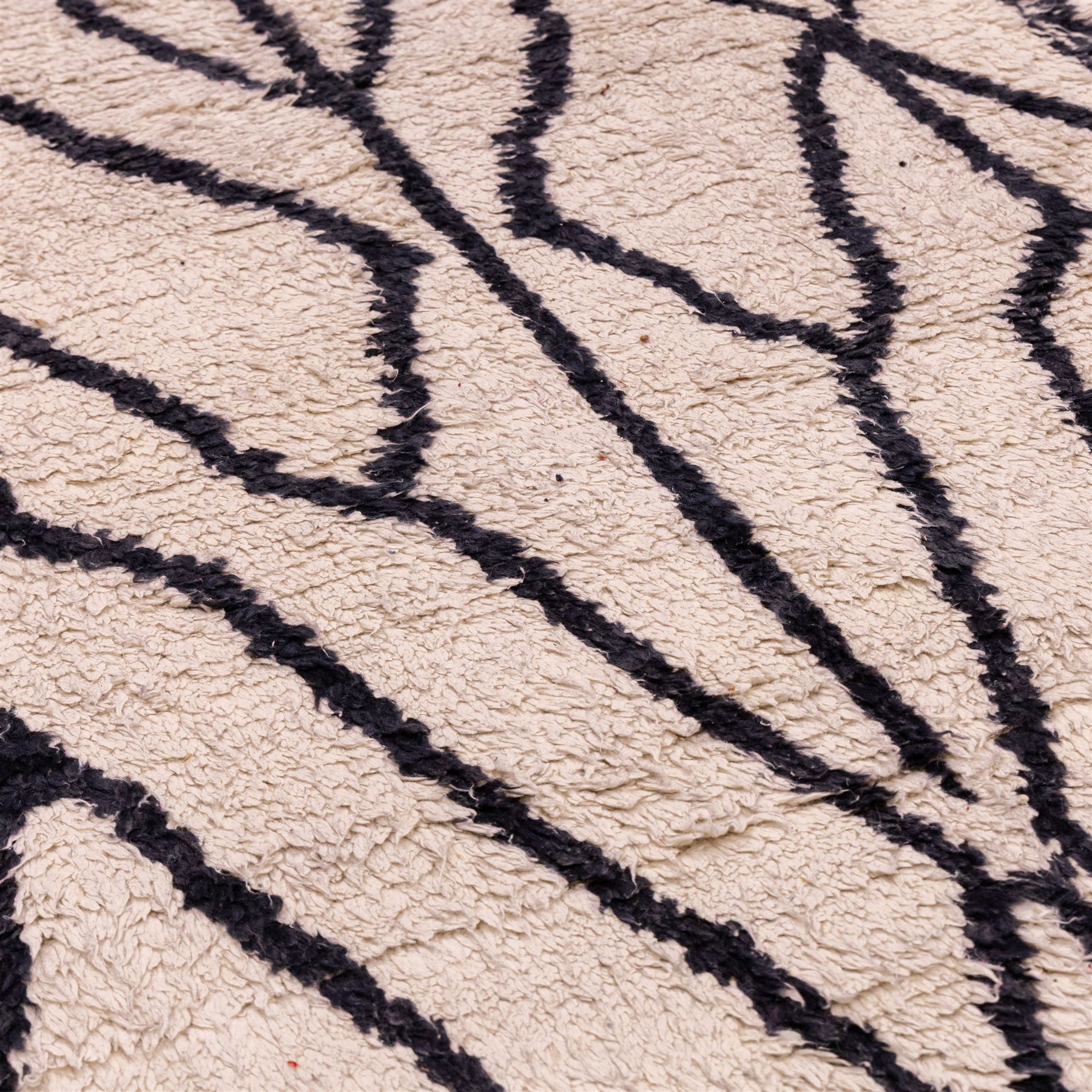 Moroccan Berber wool hand knotted rug, the cream ground decorated with abstract diamond forms and angular lines in dark brown, enclosed by a simple patterned border, with short fringe ends