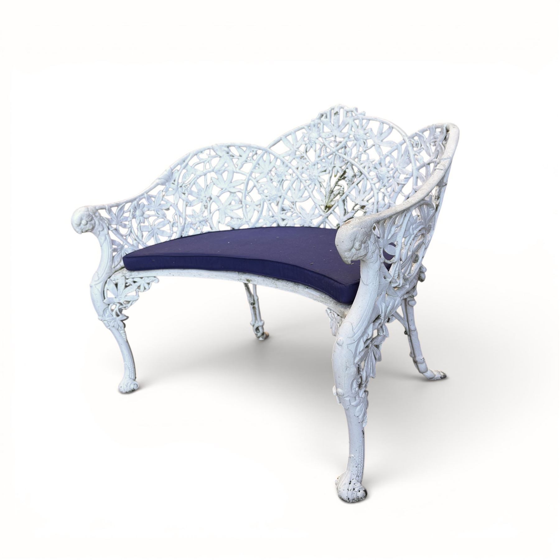 Victorian revival cast two seat garden bench, scrolling lattice back with flower heads, terminating to rams heads arms, curved pierced seat, finished in antique white paint