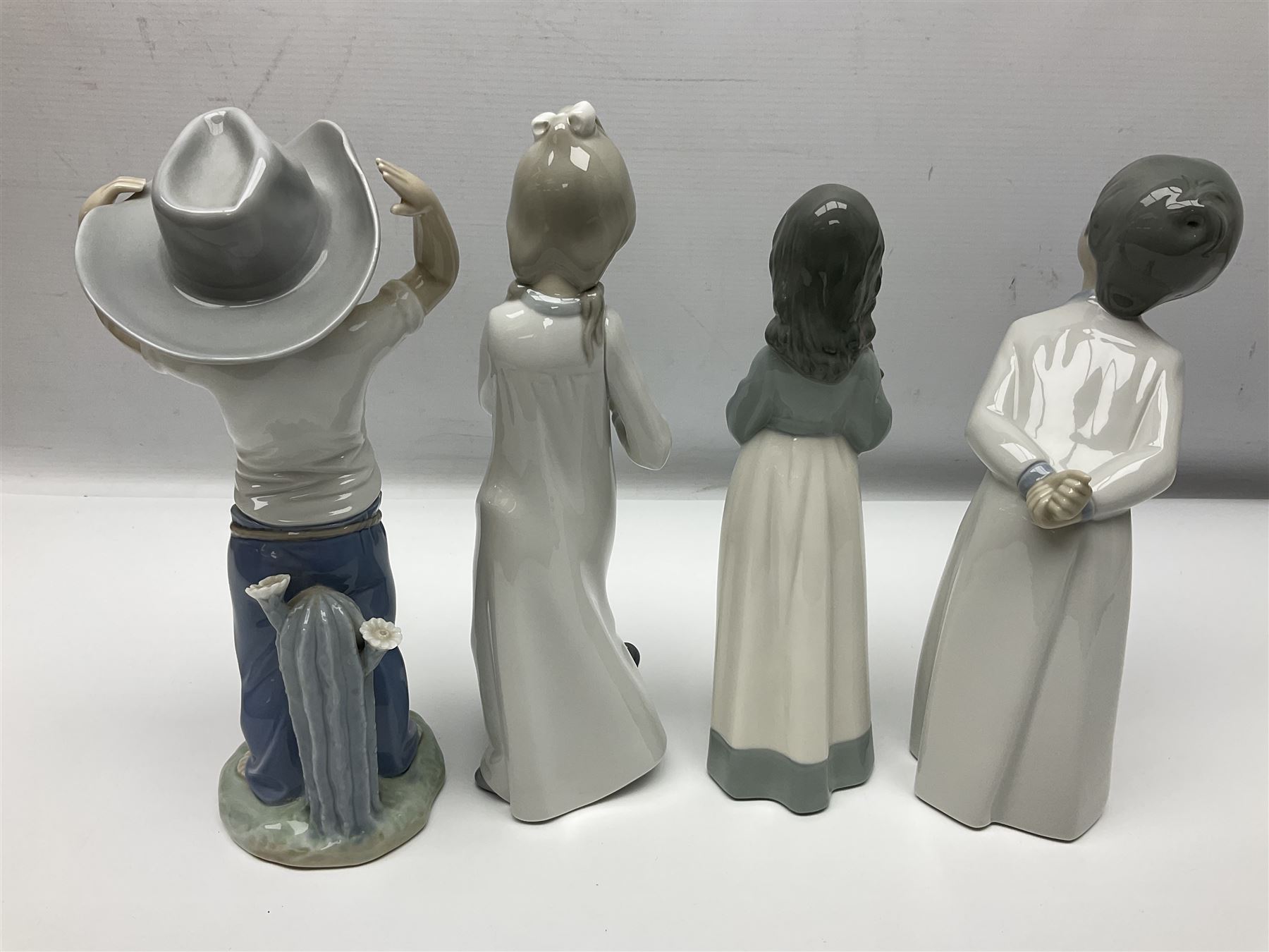 Eleven Nao figures to include Cowboy, Girl with Puppy, Clown, Girl in hat etc 