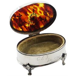 Edwardian silver and tortoiseshell mounted jewellery box, of oval form, the hinged cover with husk rim and silver inlaid ribbon swag and musical trophy decoration to the tortoiseshell panel, upon four foliate mounted paw feet, hallmarked Mappin & Webb Ltd, London 1909, together with a silver nurses buckle, with pierced zoomorphic decoration, hallmarked Levi & Salaman, Birmingham 1894, approximate weighable silver 1.38 ozt (43 grams)