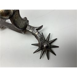 Single South American gaucho steel spur with large 15cm diameter twenty-four spike heel rowel L30cm; and another similar smaller steel spur with silver mounts (2)