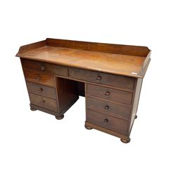 19th century mahogany knee hole desk, rectangular top with raised back, eight drawers with turned handles, skirted base on compressed bun feet