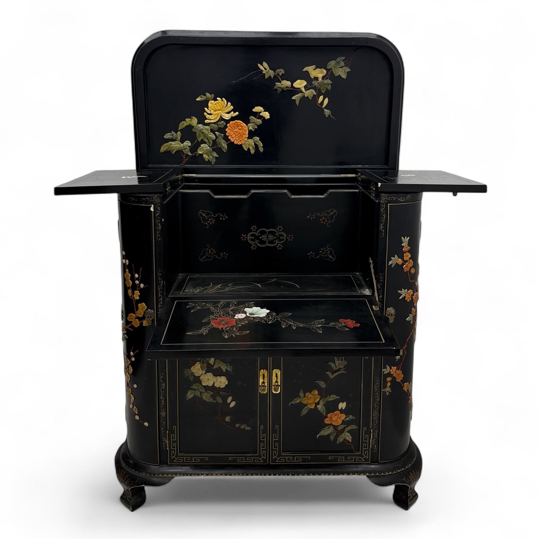 Early 20th century Chinoiserie lacquered cabinet, rounded rectangular top above a fall front enclosing fitted interior with lacquered decoration, over a pair of cupboard doors and flanked by side compartments with tiered bottle shelves, the black lacquer ground decorated throughout with raised and painted floral sprays, on shaped bracket feet