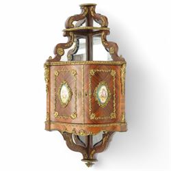 Pair of late 19th to early 20th century Kingwood and ormolu mounted encoignure or wall hanging corner cabinets, shaped end supports with mirror backs, serpentine double cupboard mounted by sevres design porcelain panels, decorated with foliate cast metal mounts, the interior fitted with shelf