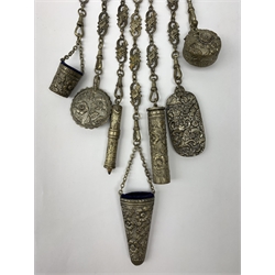 A Victorian metal chatelaine, the scrolling pierced and mask and putti decorated clip suspending seven chains with accessories, to include 
pencil holder, ivory paged aide memoire, and winding tape measure, each with relief foliate decoration, L40cm. 