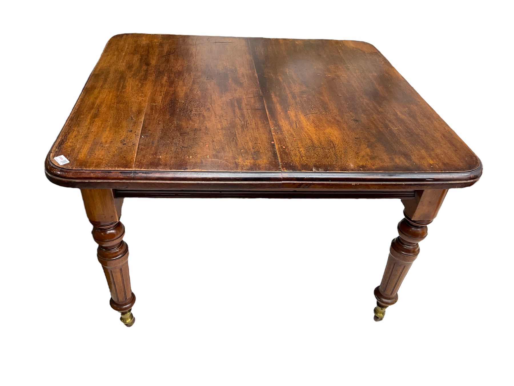 19th century mahogany extending dining table, moulded rectangular top with rounded corners, on turned and fluted supports with brass and ceramic castors