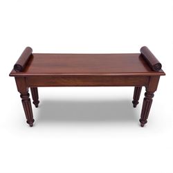 Regency style mahogany window seat, in the manner of George Bullock, with rectangular top with twin scroll ends, raised on four turned and reeded supports terminating in bun feet