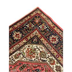 North West Persian pink ground Tabriz carpet, central indigo ground medallion surrounded by stylised plant motifs and trailing foliage, the main border with overall floral design within guard stripes 