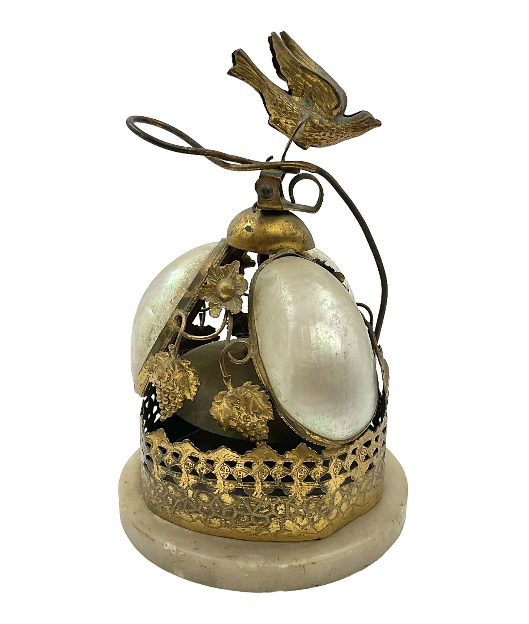 Victorian evening dinner bell, with three mother of pearl shells, floral and grape gilt decoration, and bird finial, raised upon a circular soapstone base with gilt pierced gallery, H14cm