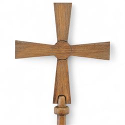 Early 20th century Arts and Crafts 6’ oak processional cross, the tapered cruciform head with circular boss, mounted on a long cylindrical octagonal shaped staff
