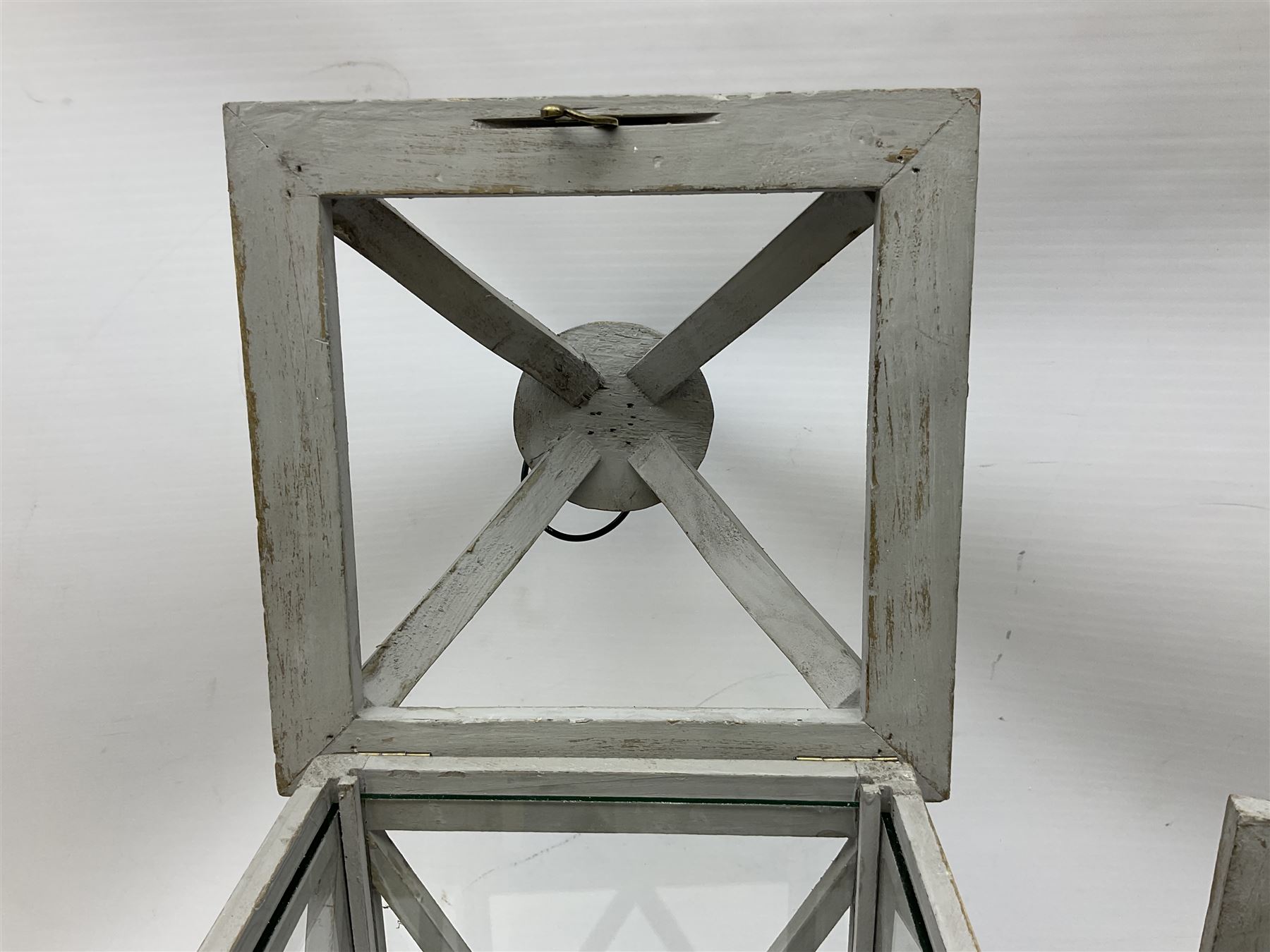 Two wooden lanterns with four glass sides, loop handles and open tops, largest example 58cm