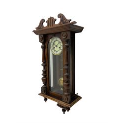 Small Spring driven German wall clock in a mahogany case with turned columns and pendants, with a fully glazed door and gridiron pendulum, ivorine dial with Roman numerals and gothic steel hands, eight day movement striking the hours on a gong.