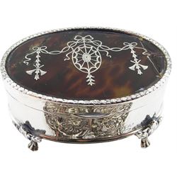 Edwardian silver and tortoiseshell mounted jewellery box, of oval form, the hinged cover with husk rim and silver inlaid ribbon swag and musical trophy decoration to the tortoiseshell panel, upon four foliate mounted paw feet, hallmarked Mappin & Webb Ltd, London 1909, together with a silver nurses buckle, with pierced zoomorphic decoration, hallmarked Levi & Salaman, Birmingham 1894, approximate weighable silver 1.38 ozt (43 grams)
