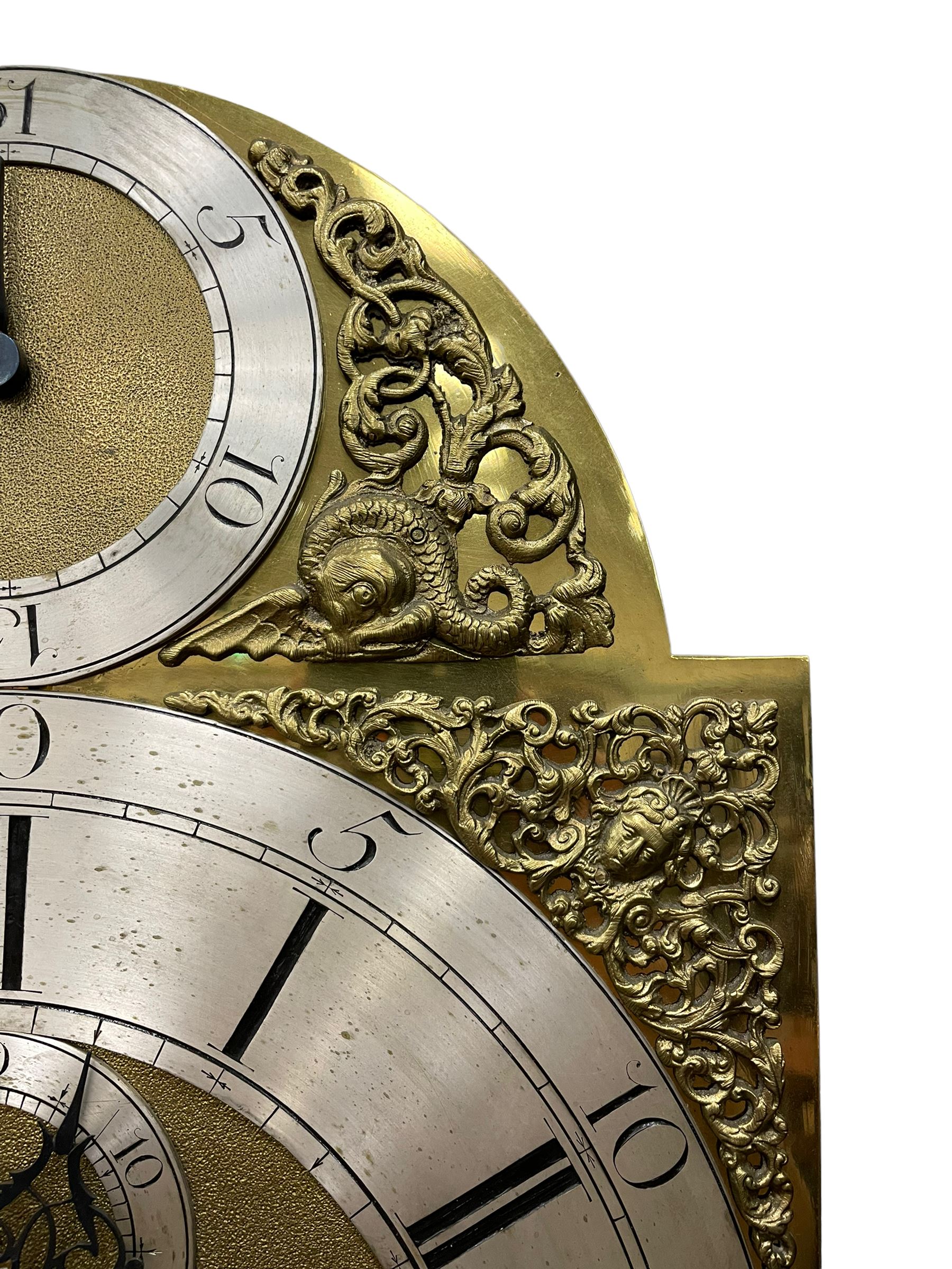 Henry Hindley of York – mid-18th century oak cased 8-day longcase clock,
flat topped caddy pediment with gesso finials, rectangular hood door flanked by wooden turned pilasters with capitals, canted trunk with a full-length break arch topped door on a short plinth with applied skirting and bracket feet, brass dial with a silvered chapter ring, Roman numerals and five-minute Arabic’s, minute and inner quarter hour tracks, matted dial centre with subsidiary seconds dial, blued steel hands and female head pattern spandrels, silvered calendar dial to the break arch with dolphin spandrels, four pillar rack striking movement, striking the hours on a bell. With weights and pendulum. 
H250 W48 D27
Henry Hindley originally from Wigan (Lancs) is recorded as working in York from Petergate 1731-41 then Stonegate 1741-1771. A famous and highly innovative maker, often referred to as the “Tompion of the North.” 
