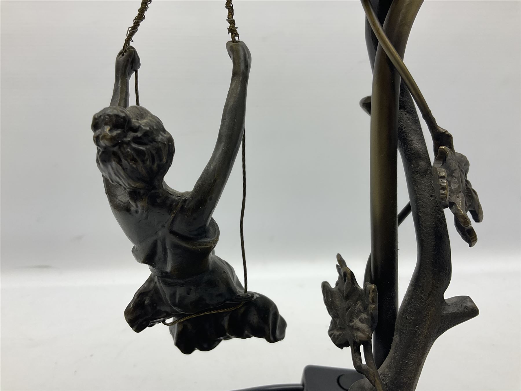 Art Nouveau style lamp in the form of a woman on a swing, with a green mottled shade, upon a marble base H52cm