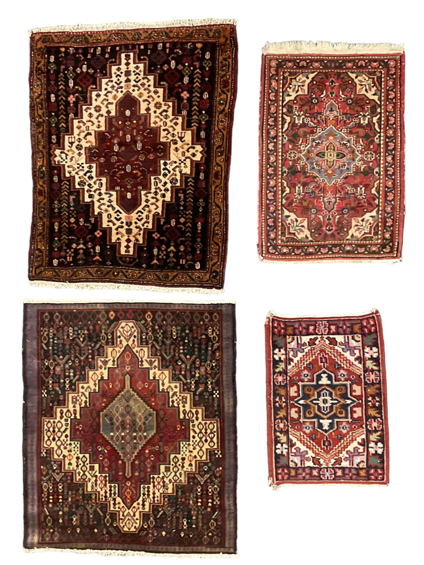 Small Hamadan dark indigo ground rug, central ivory and maroon lozenge with geometric decoration, guarded border with repeating stylised plant motifs, together with three others (4)