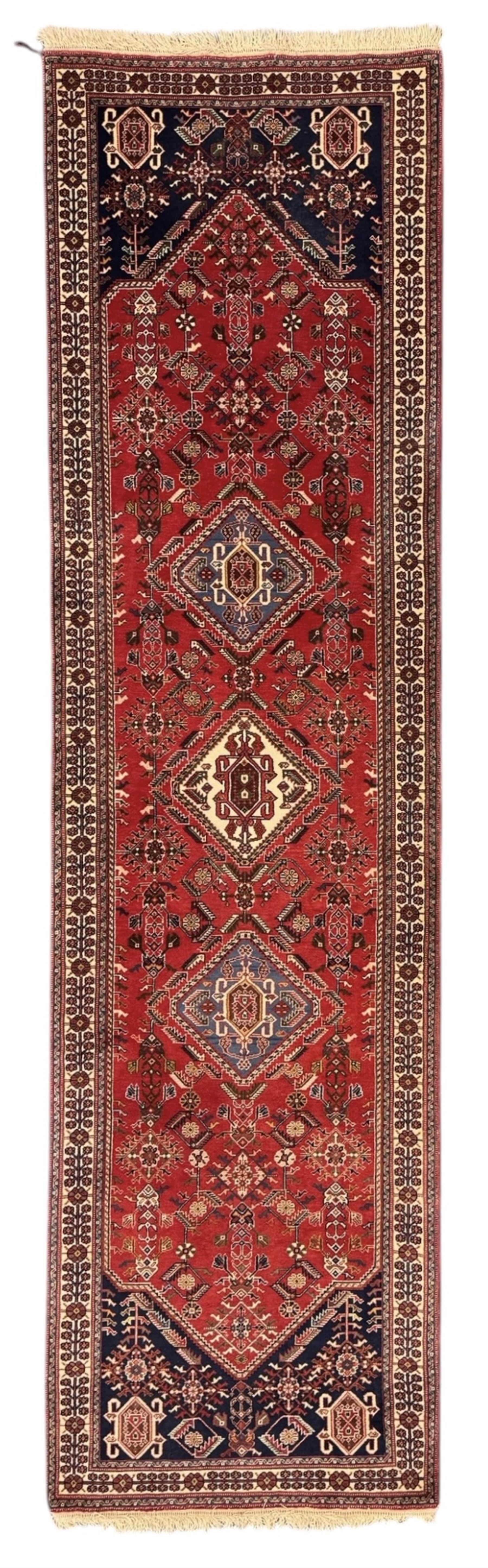 Persian Qashqai crimson ground runner, the central field decorated with three large geometric medallions with intricate angular and floral motifs, the indigo spandrels with complementary geometric designs, bordered by an ivory band with repeating floral patterns and angular vines