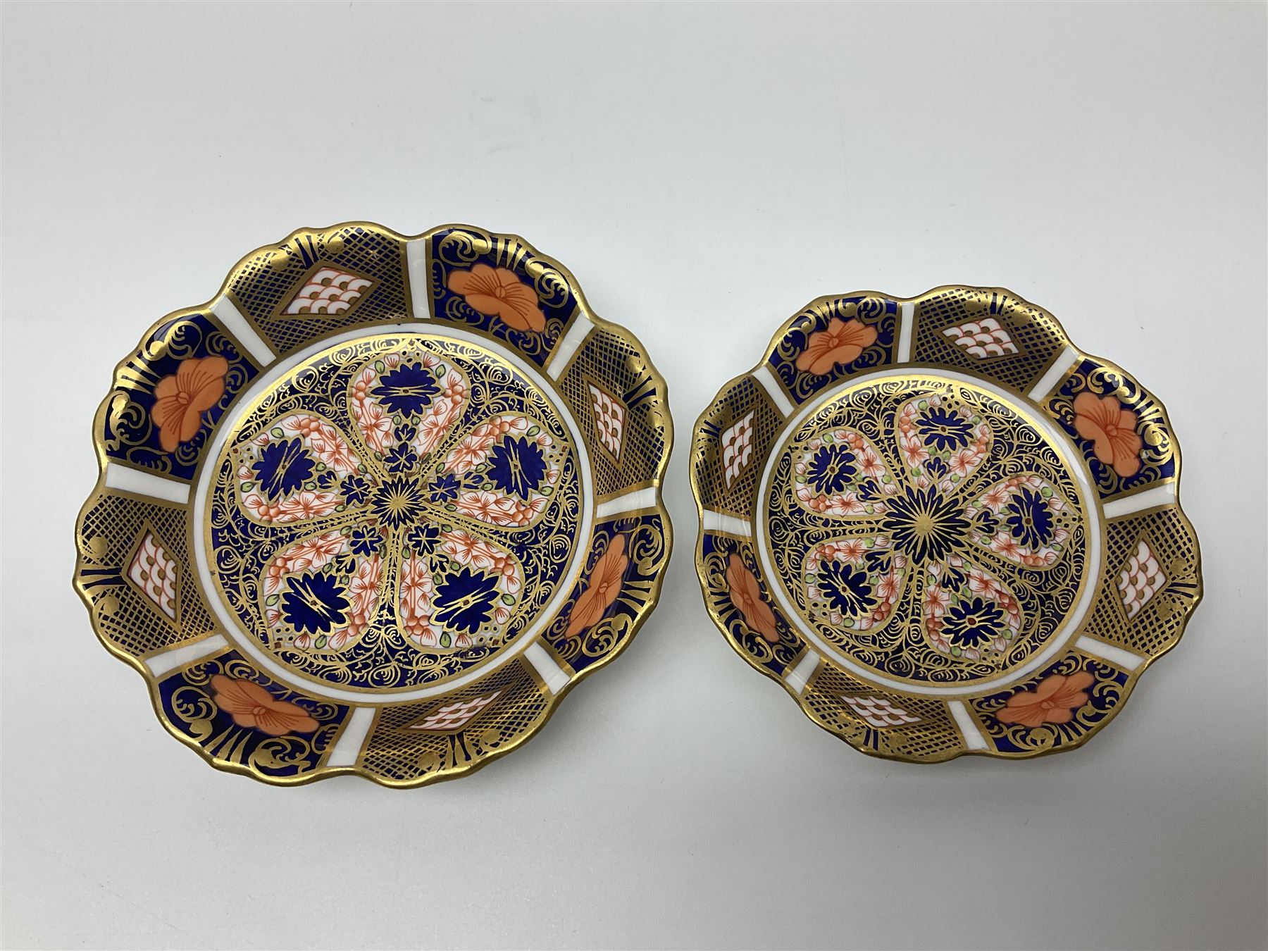 Two Royal Crown Derby Goldfinch Nesting paperweights with silver stoppers, together with two Royal Crown Derby imari pin dishes, largest dish D13cm