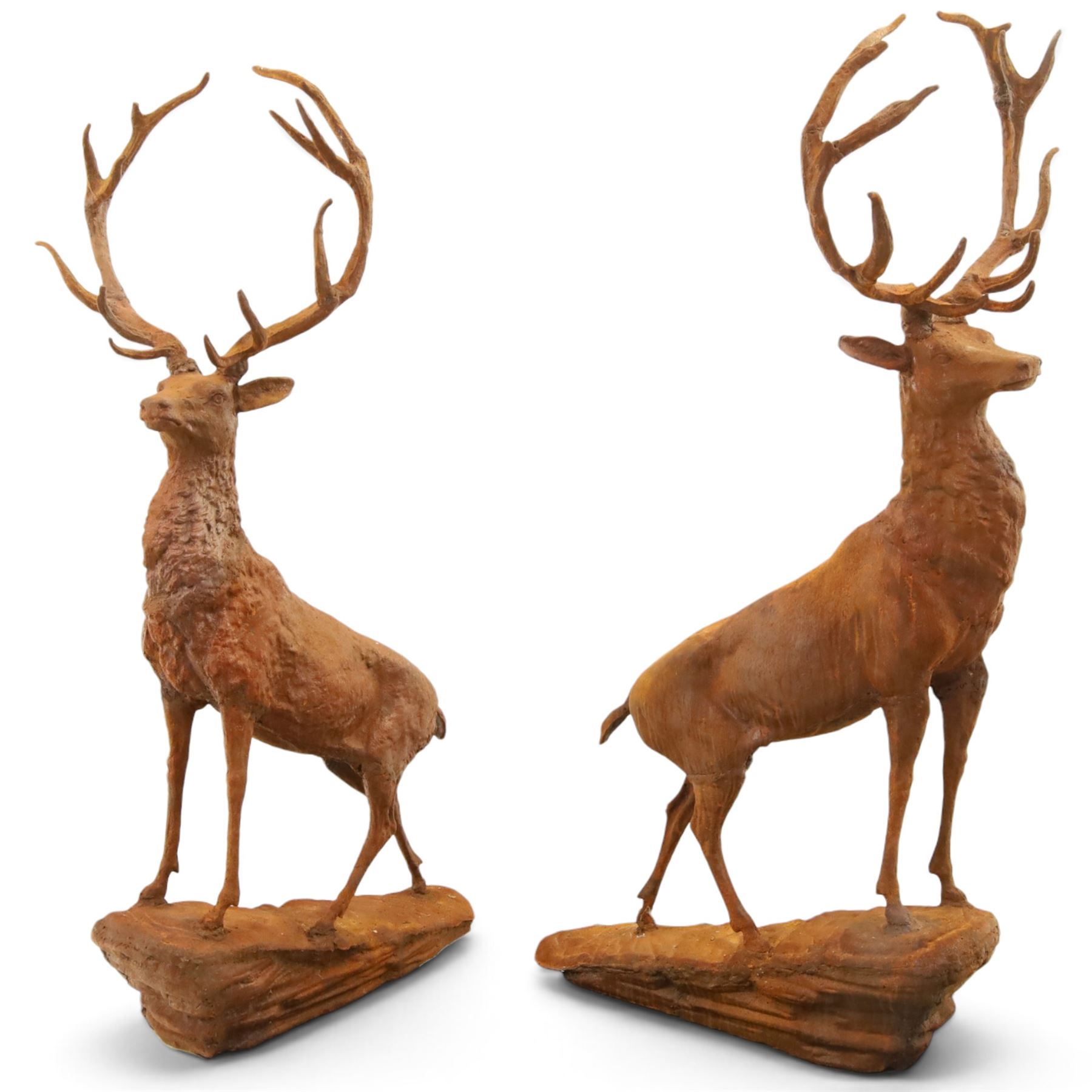 Pair of cast iron stags, upon a on moulded rocky plinth, standing alert 