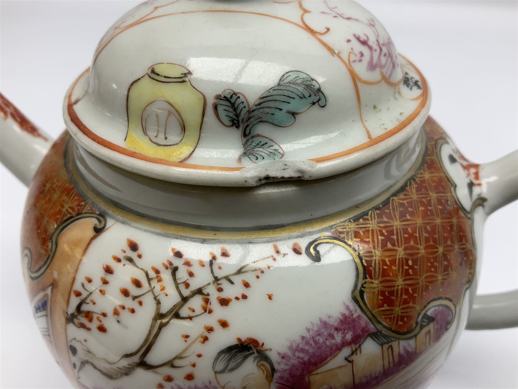 Two late 18th/early 19th century Chinese export teapots, the largest example of globular form with curved handle and straight spout, decorated in the Mandarin style with figural scenes surrounded by red scale reserves, H13.5cm, the second smaller example decorated in underglaze blue with two musicians in a landscape set with willow tree and fence, H10.5cm

