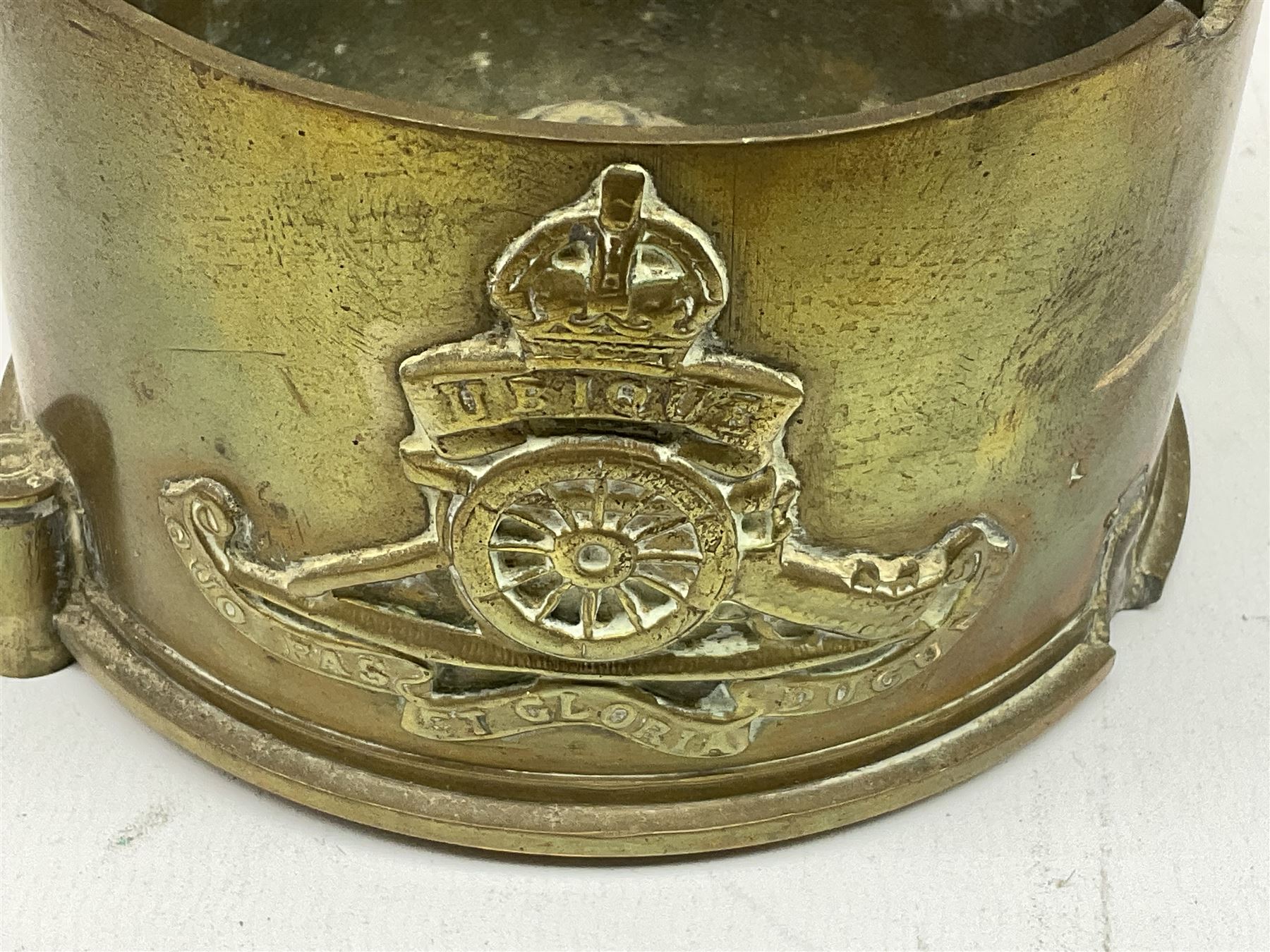 Trench Art - three WW2 brass shell case ashtrays, one mounted with Royal Artillery cap badge and button and one mounted with RA button; together with a pair of place name holders each formed from a Royal Artillery cap badge (5)