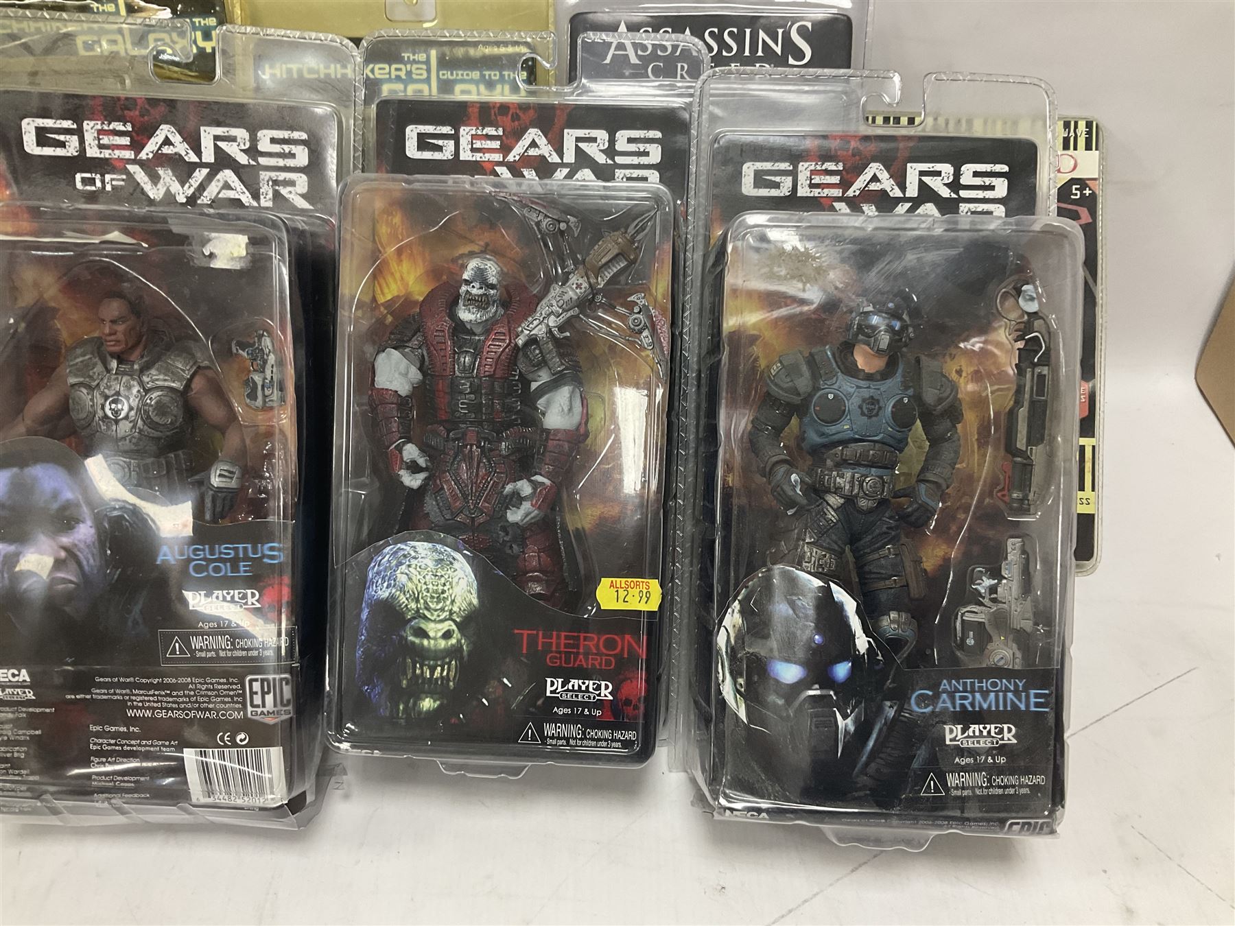 Sixteen carded action figures comprising seven 'Gears of War'; four 'Hitchhikers Guide to the Galaxy'; two 'Torchwood'; 'Planet of the Apes'; 'Bruce Lee'; and 'Assassin's Creed'; all in unopened packs (16)