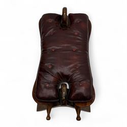 Pair of early 20th century Anglo-Indian camel saddle stools, with deep buttoned red leather upholstered seats and horn-shaped pommels, on X-form supports with turned ball finials