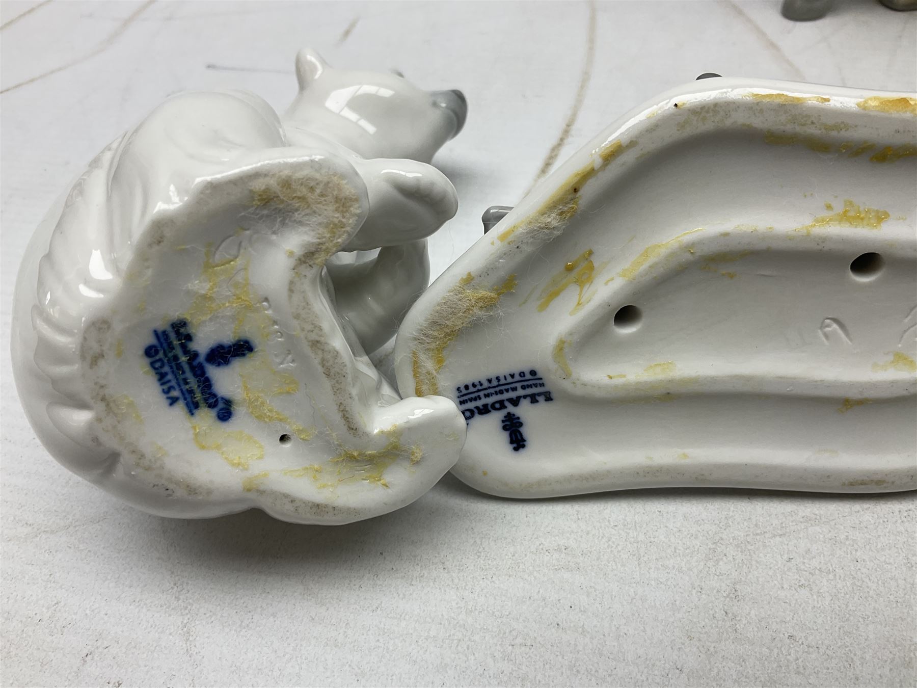 Seven Lladro figures, comprising Playful Puppy no 9135, Platero and Marcelino/Boy Hugging Donkey no 1181, Mini Seal Family no 5318, Attentive Polar Bear no 1207, Seated Polar Bear no1209, Eskimo Boy with Pet no 5238 and Girl with Geese no 1035, together with Nao goose