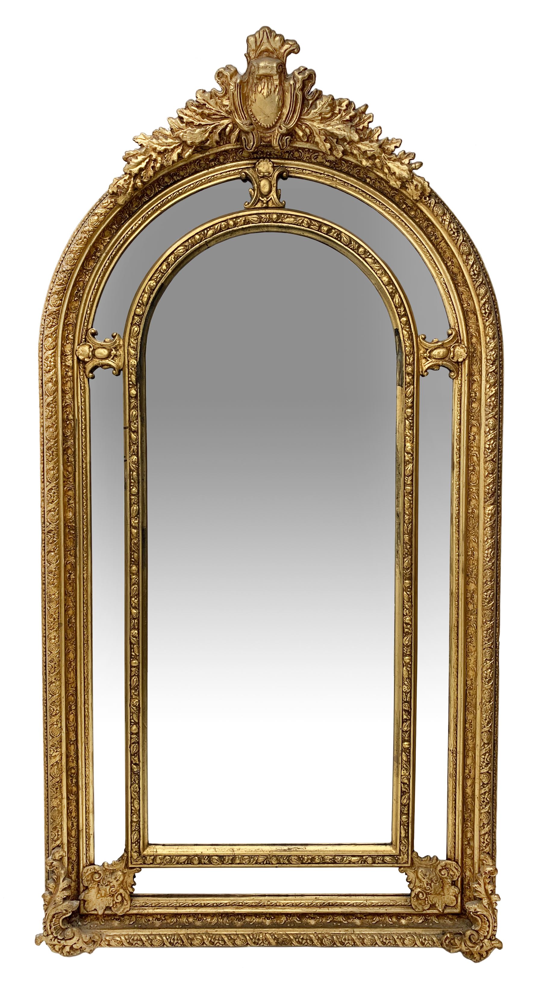 Gilt Rococo style mirror, arched top with central cartouche and oak leaf moulded pediment, floral and fruit moulded surround with segmented glass panels, bevelled central pane, c-scroll shell and acanthus leaf brackets