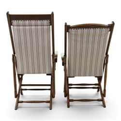 Pair of early 20th century oak framed garden reclining and folding deckchairs, high back and seat upholstered in striped fabric with padded armrests
