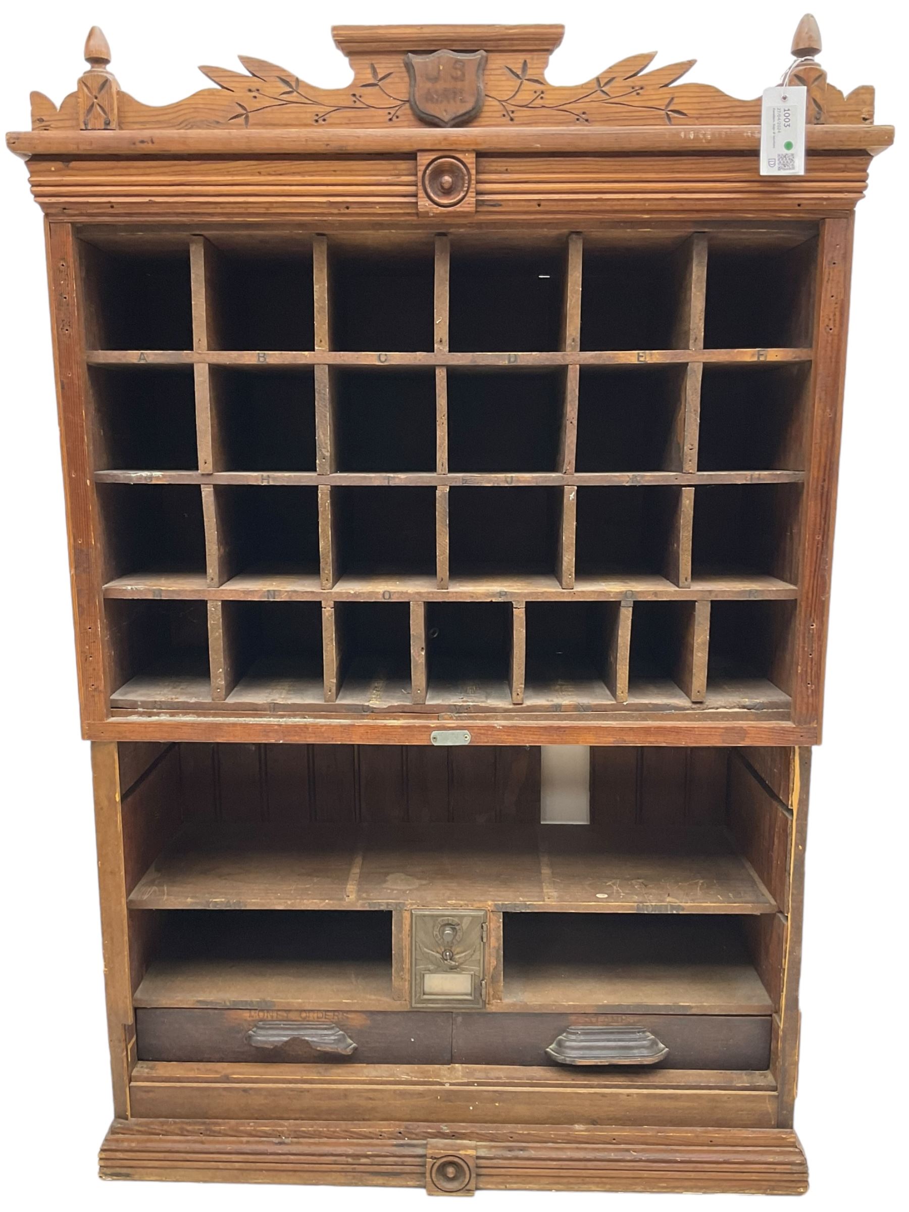 19th century stained pitch pine 'US Mail' pigeonhole unit, raised carved gallery with applied inscribed shield plaque, fitted with twenty five pigeon holes over shelves and correspondence drawers