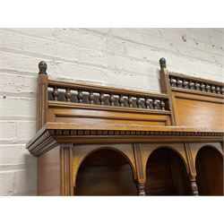 Late Victorian walnut dresser, the raised panelled back fitted with panelled cupboards, shelves and bevelled mirrors, moulded rectangular top over three drawers and cupboards, the left-hand cupboard fitted with two slides and the right-hand cupboard fitted with revolving drinks stand, on turned feet