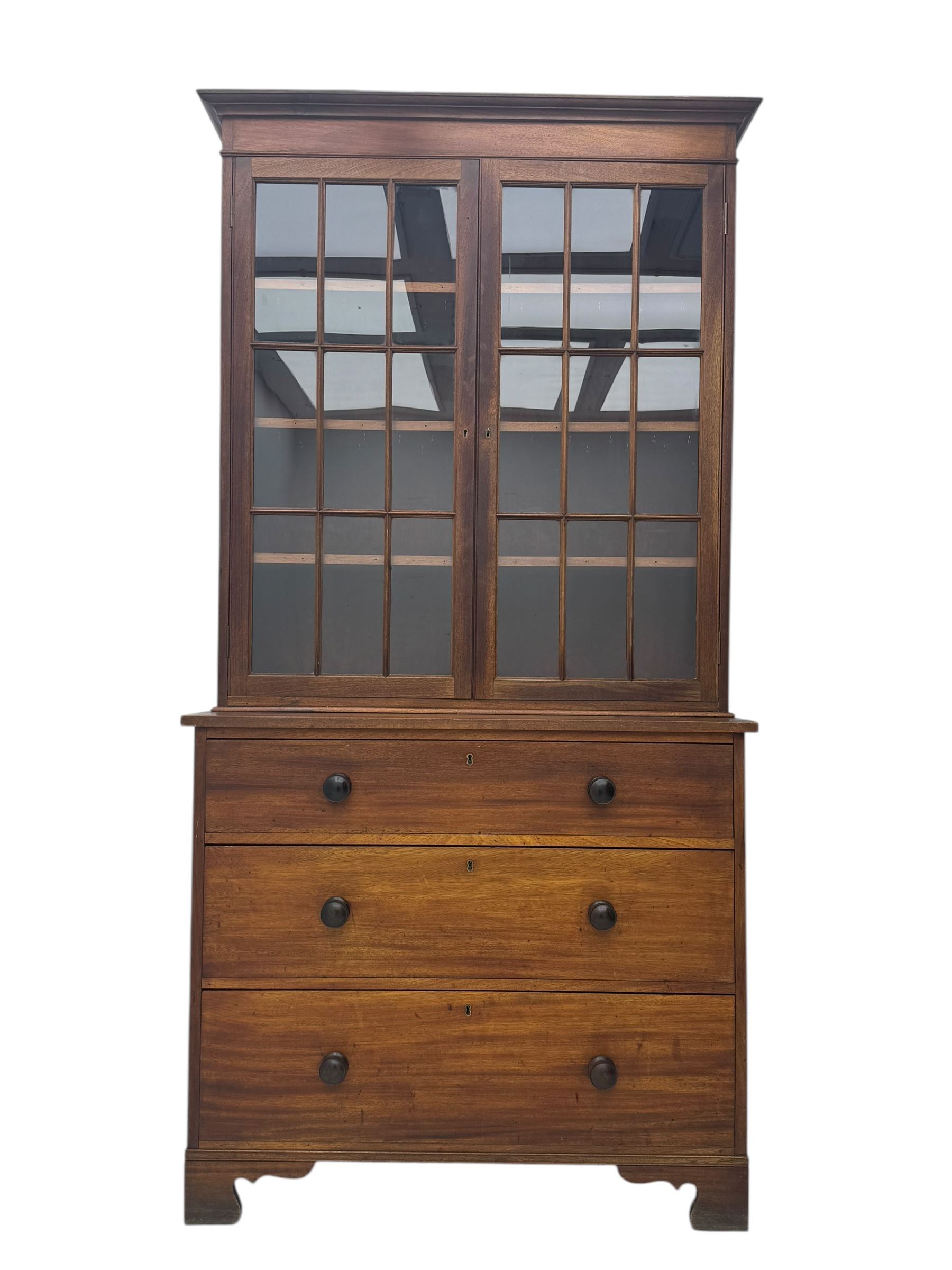 Late 19th century mahogany bookcase on chest, projecting moulded cornice over twin astragal glazed doors enclosing three shelves, base fitted with three graduated drawers, raised on shaped bracket supports