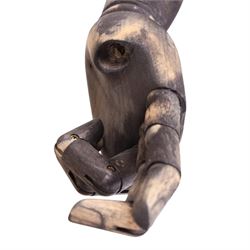 Male mannequin torso with fabric body and poseable wooden arms, on a square metal base