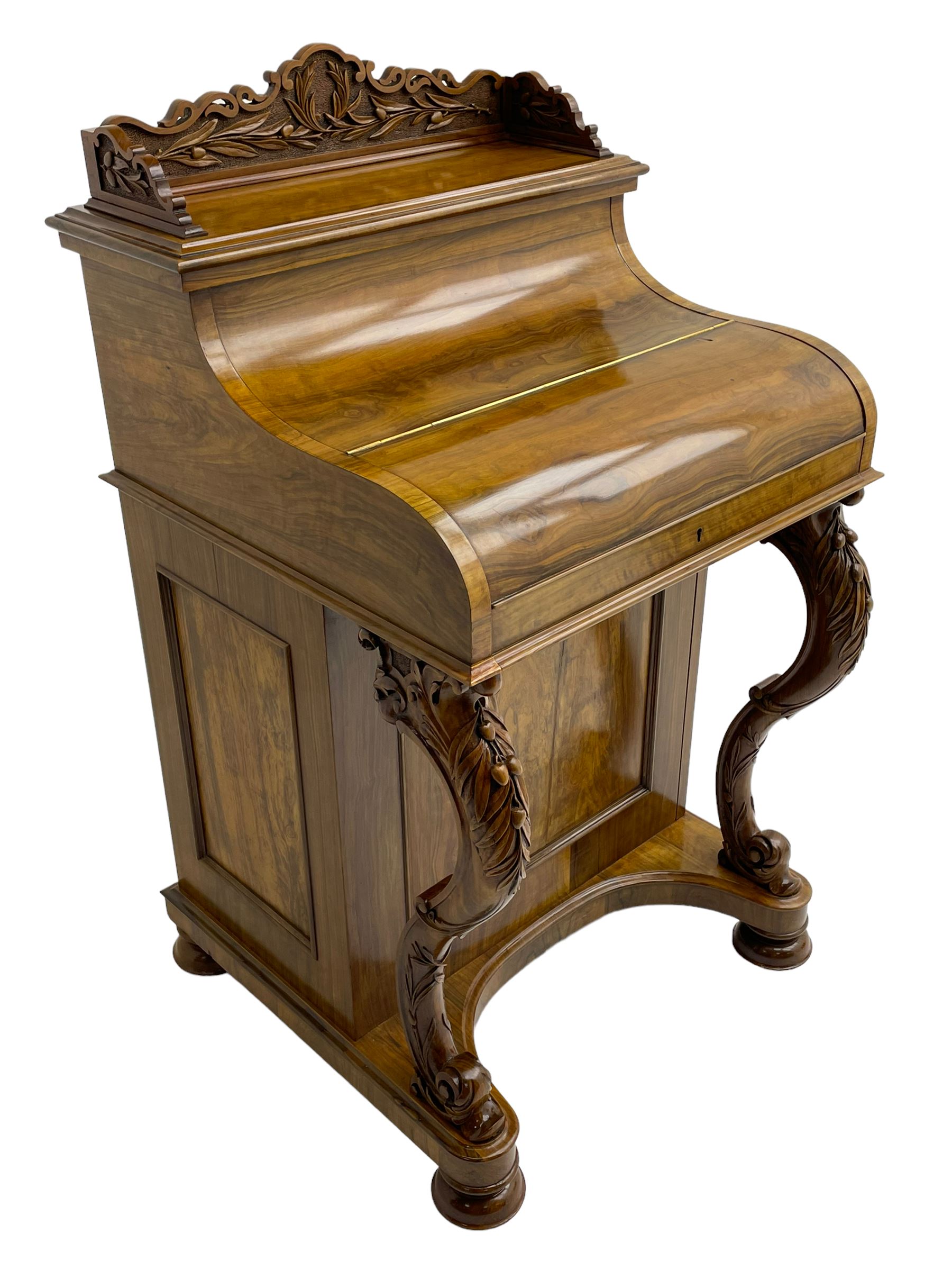 Fine and unusual 19th century olivewood piano top davenport, raised shaped back carved with olive branches and olives, the top hinges to reveal lidded and correspondence compartments, the piano lid enclosing sliding top with hinged and adjustable writing surface with leather inset, right-hand panelled door enclosing four drawers, olive branch and scroll carved cabriole front supports on moulded and shaped platform, turned cup feet with recessed castors 
